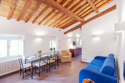 a living room with a blue couch and a table and chairs at Domizio in Rome
