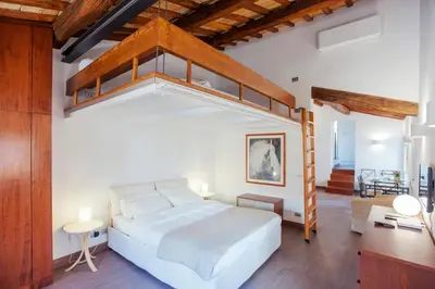 a bedroom with a loft bed and a desk at Domizio in Rome