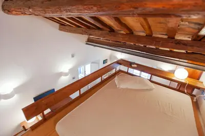 a large bed in a room with wooden ceilings at Domizio in Rome