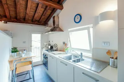 a kitchen with white cabinets and a sink and a window at Domizio in Rome