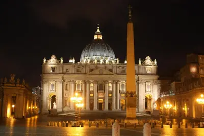 a large building with a tower in front of it at night at Old Town Apartments Rome in Rome