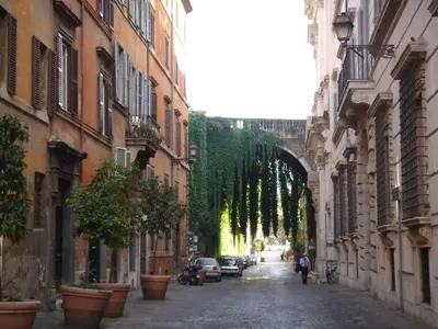 an alley with buildings and a person walking down a street at Old Town Apartments Rome in Rome