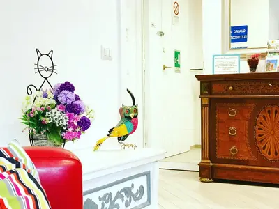 a colorful bird statue sitting on a mantle next to a vase of flowers at Trastevere Vintage Rosazza in Rome