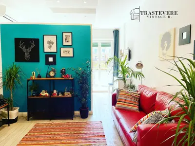 a living room with a red couch and plants at Trastevere Vintage Rosazza in Rome