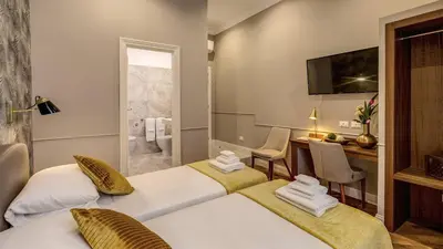 a hotel room with two beds and a desk at Charme Spagna Boutique Hotel in Rome