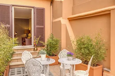 two tables and chairs on a patio with plants at Charme Spagna Boutique Hotel in Rome