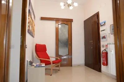 a room with a red chair and a door at Emilio's Home in Rome