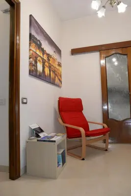 a red chair sitting in a room next to a door at Emilio's Home in Rome