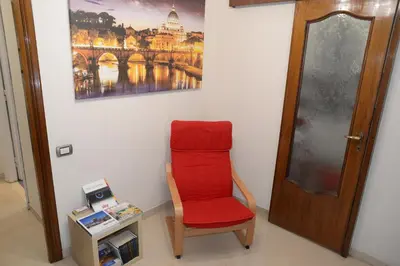 a red chair in a room with a picture on the wall at Emilio's Home in Rome