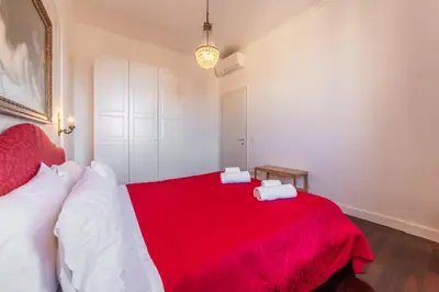 a bedroom with a red bed with white pillows at Moma Domus - Golden Keys Collection in Rome