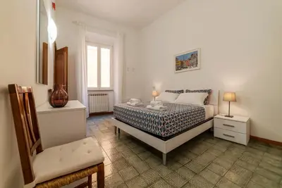 a bedroom with a bed and a chair in it at Casa dell'Arco - WelcomeToRhome in Rome