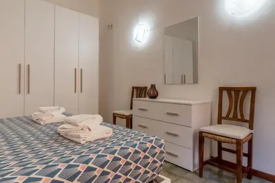 a bedroom with two beds and a dresser and two chairs at Casa dell'Arco - WelcomeToRhome in Rome