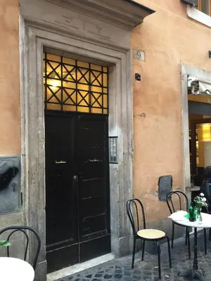 a black door in a building with tables and chairs at Sweet Life Trevi Roma in Rome