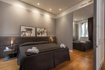 a bedroom with a bed and a room with a desk at Amazing Suite Piazza Venezia in Rome
