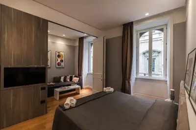 a bedroom with a bed and a tv and a couch at Amazing Suite Piazza Venezia in Rome