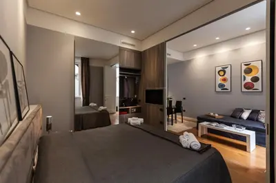 a bedroom with a large bed and a living room at Amazing Suite Piazza Venezia in Rome