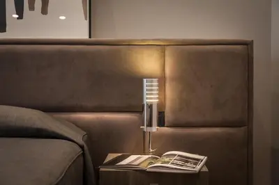 a lamp on a table next to a couch with a book at Amazing Suite Piazza Venezia in Rome