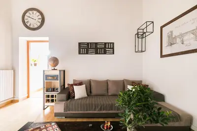a living room with a couch and a clock on the wall at Home Domus Borgo Pio - San Pietro in Rome