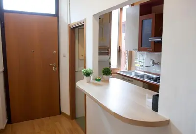 a kitchen with a counter top and a wooden door at Home Domus Borgo Pio - San Pietro in Rome