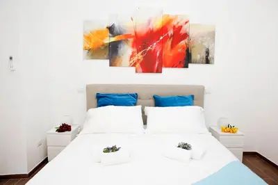 a bedroom with a white bed and a painting on the wall at Castel Sant Angelo's Harmonious Apartment in Rome