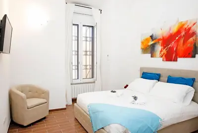a bedroom with a bed and a chair at Castel Sant Angelo's Harmonious Apartment in Rome