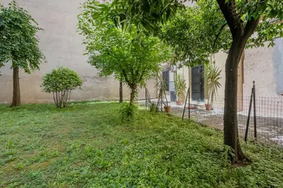 a yard with trees in front of a building at Castel Sant Angelo's Harmonious Apartment in Rome
