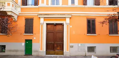 an orange building with a green door and windows at Castel Sant Angelo's Harmonious Apartment in Rome