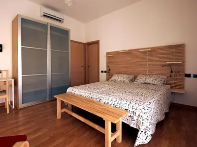 a bedroom with a bed with a wooden headboard at Casa Vacanze Shivon in Rome