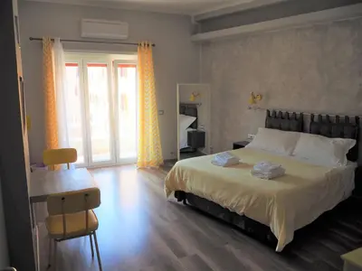 a bedroom with a large bed and a table and chairs at Bed and Breakfast New Morning Holiday in Rome