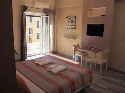 a bedroom with a bed and a desk and a window at Bed and Breakfast New Morning Holiday in Rome