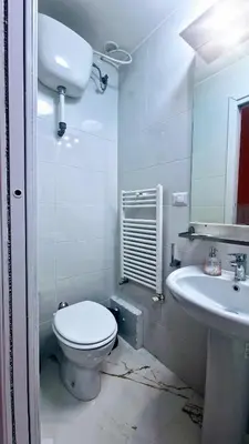 a white bathroom with a toilet and a sink at Oscar Rooms in Rome