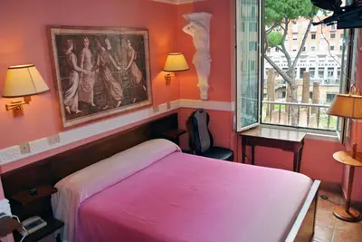 a bedroom with a bed and a painting on the wall at Hotel Barrett in Rome