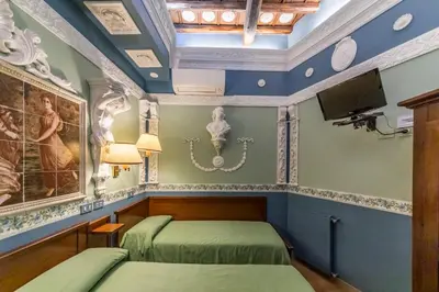 a bedroom with two beds and a tv on the wall at Hotel Barrett in Rome