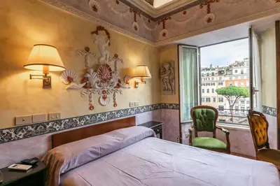a bedroom with a bed and a chair and a window at Hotel Barrett in Rome