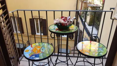 a balcony with three chairs and a bowl of candy at Hotel Barrett in Rome