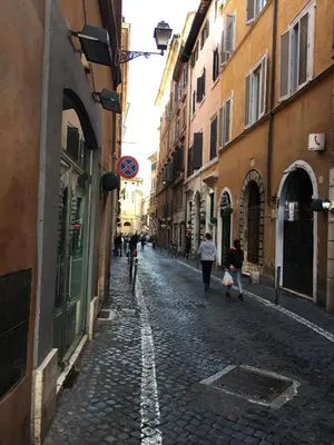 a cobblestone street with people walking down the street at Pantheon Old Suite in Rome