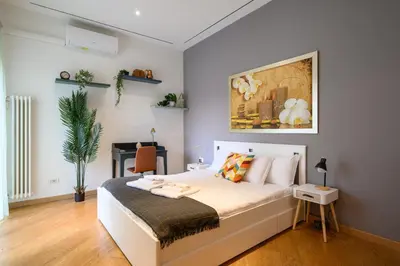 a bedroom with a white bed and a desk at Studio via Nicola Fabrizi in Rome