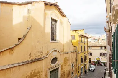 an old yellow building in a city with a street at Trans Tiberim in Rome