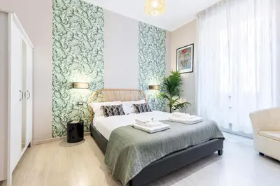 a bedroom with a bed with a green accent wall at Rome as you feel - Diocleziano Apartment in Rome