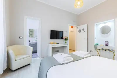 a white room with a bed and a chair at Rome as you feel - Diocleziano Apartment in Rome