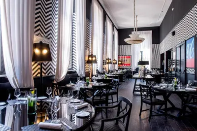 a dining room with tables and chairs and windows at TH Roma - Carpegna Palace in Rome