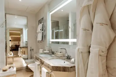 a bathroom with a sink and a toilet and a mirror at Aleph Rome Hotel, Curio Collection By Hilton in Rome
