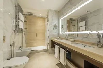 a bathroom with a sink and a tub and a toilet at Aleph Rome Hotel, Curio Collection By Hilton in Rome