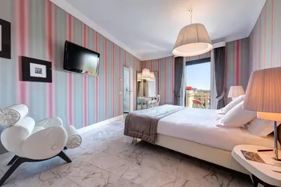 a hotel room with a large bed and a tv at Grand Hotel Palace Rome in Rome