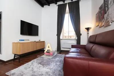 a living room with a couch and a flat screen tv at Andreasuite Trastevere in Rome