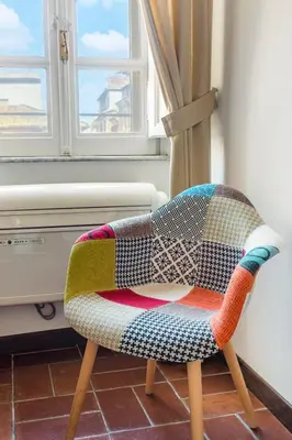 a colorful chair in a room with a window at Andreasuite Trastevere in Rome