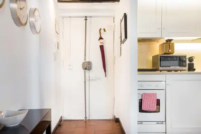 a kitchen with a white door and a microwave at Andreasuite Trastevere in Rome