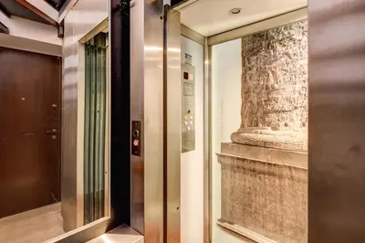 a elevator in a building with a stone wall at Pantheon Miracle Suite in Rome