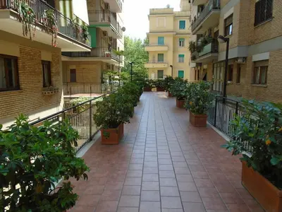 an empty walkway with potted plants in a courtyard at La Tana di Sofia in Rome