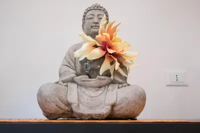 a statue of a buddha holding a flower at The Apartment Trastevere - Ba.home in Rome